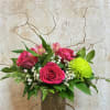 Pink roses and alstroemeria in a textured vase with bright green chrysanthemum