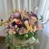 Mixed bouquet of roses, carnations, and small blooms in a glass vase