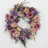 Circular floral wreath with purple, pink, and cream flowers