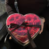 Heart-shaped box of red roses tied with a black ribbon