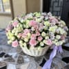 Large basket of pink and white flowers with a lavender ribbon