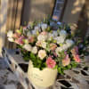 Mixed pink and white flowers in a cream hatbox