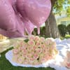 Pink heart balloons above a large bouquet of pale pink roses