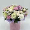 Pastel bouquet of roses, carnations, and alstroemeria in a pink box