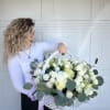 Large white basket of white and pale green roses with eucalyptus