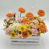 Bright mixed flower arrangement in a white wooden crate