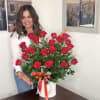 Large bouquet of red roses in a white hatbox with a red ribbon