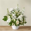White floral arrangement in a white basket vase