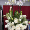 White orchid and rose arrangement in a gold vase