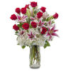 Red roses and pink lilies arranged in a clear glass vase