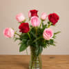 A loose cluster of pink and red roses arranged at varying heights