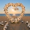 A heart-shaped floral arch of white roses and delicate white filler blooms