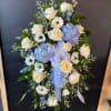 Standing floral spray with white roses, blue hydrangeas, and a ribbon bow