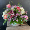 Pink and white tulips with roses and orchids in a round vase