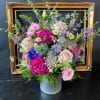 Mixed pink, purple, and white flowers in a ribbed metal container
