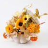 Orange and yellow floral arrangement in a white pumpkin container