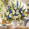 White and blue floral arrangement in a white vase