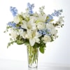 White roses, delicate delphinium, and blooming lilies come together for a luxurious