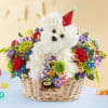 White teddy bear in a basket surrounded by colorful flowers and ribbons
