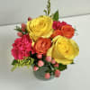 Bouquet of yellow, orange, and pink flowers in a glass vase