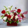 Mixed bouquet of red, white, and pink flowers in a red box