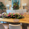 Long pink and white floral table runner with matching tall arrangement on a dining sideboard