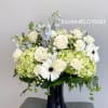 White roses and green hydrangeas in a dark blue vase