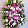 Large standing spray of pink, white, and purple flowers on an easel