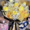 Bouquet of yellow roses with white baby's breath in gold and black wrap