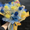 Bouquet of blue and yellow roses with baby's breath and colorful wrapping