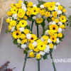 Yellow floral heart wreath on a stand with roses and daisies