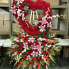 Large heart-shaped floral standing spray with red roses and pink lilies