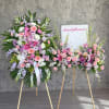 Two pastel floral standing sprays on easels with pink and lavender blooms