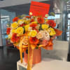 Orange and yellow bouquet with roses and gerbera daisies in a box