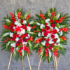 Two large standing floral sprays with red, white, and orange flowers
