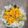 Bouquet of yellow roses with white filler flowers wrapped in pale paper