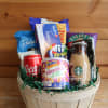 Basket of assorted snack and drink items in a wooden container