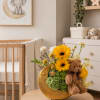 Yellow gerbera bouquet in a gold crescent vase with a teddy bear