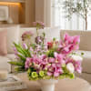 Pink orchid and tulip arrangement in a white vase