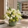 White tulips and green blooms arranged in a green vase