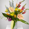 Tropical bouquet with anthuriums, orchids, lilies, and snapdragons in a glass vase