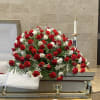 A classic sympathy casket spray featuring fresh carnations accented with greenery.