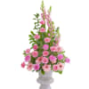 Tall pink arrangement with roses, carnations, gerbera daisies, and snapdragons in a pale pedestal vase