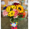 Mixed bouquet with sunflowers, roses, and pink carnations in a glass vase