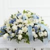 White floral arrangement with blue accents and a pale blue ribbon