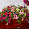 Large pink and purple floral casket spray with lilies and roses