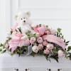 Pink rose arrangement with a teddy bear and ribbon accents