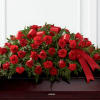 Red roses and carnations arranged with ribbon on a casket