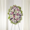 Standing floral wreath with white lilies, pink roses, and purple daisies