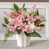 Pink lilies and roses arranged in a white vase